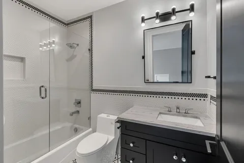 a bathroom with a sink a toilet and shower