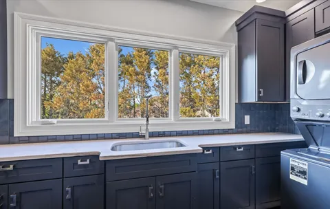 a sink with a window and cabinets