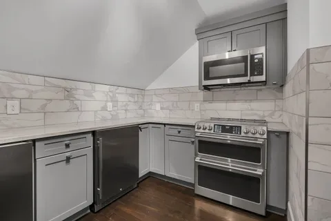 a kitchen with stainless steel appliances white cabinets and a refrigerator