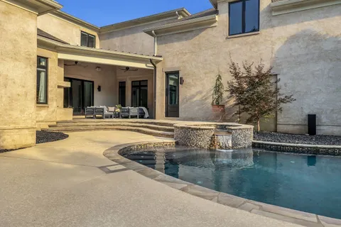 a view of a house with pool fire pit and chairs