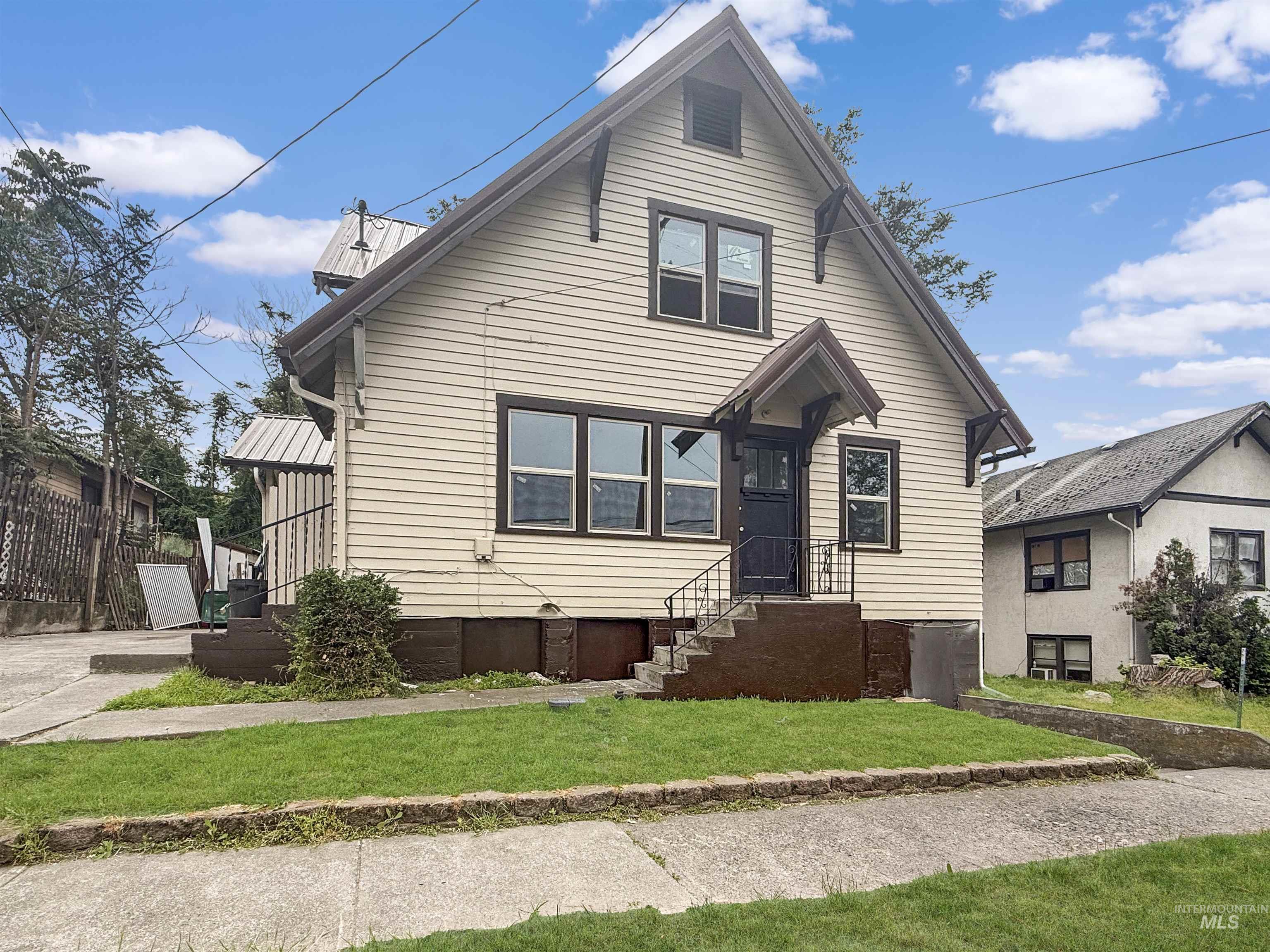 1818 7th Avenue Lewiston, ID 83501 - Photo 1 of 23 Light-colored siding exterior with dark trim and a prominent peaked gable