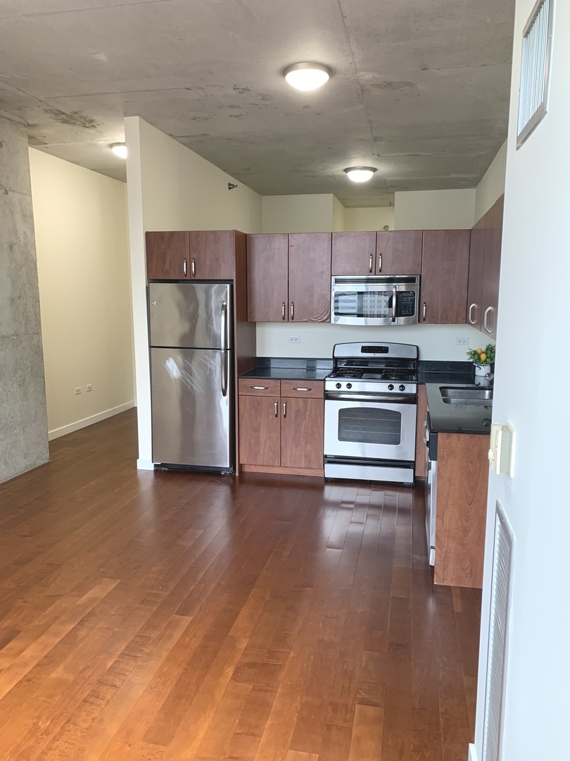 235 West Van Buren Street, Unit 3820 Chicago, IL 60607 - Photo 18 of 38 a kitchen with stainless steel appliances granite countertop a refrigerator a stove top oven a sink and dishwasher