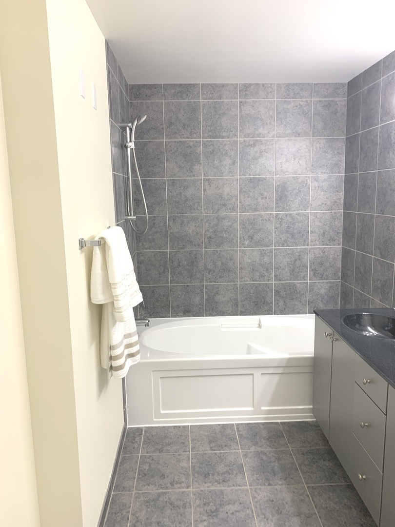 235 West Van Buren Street, Unit 3820 Chicago, IL 60607 - Photo 31 of 38 a bathroom with a bathtub and a shower