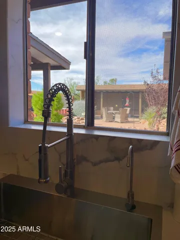a living room with stainless steel appliances furniture and a kitchen view