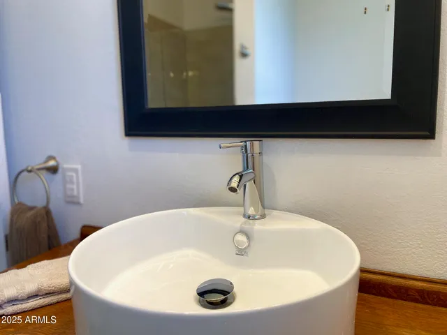 a bedroom with a bed and a mirror on the dresser