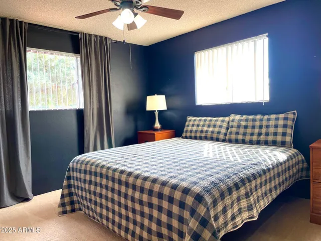 a kitchen with stainless steel appliances kitchen island granite countertop a refrigerator a stove a dining table and chairs with wooden floor