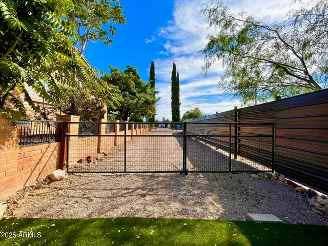 a view of a yard with wooden fence