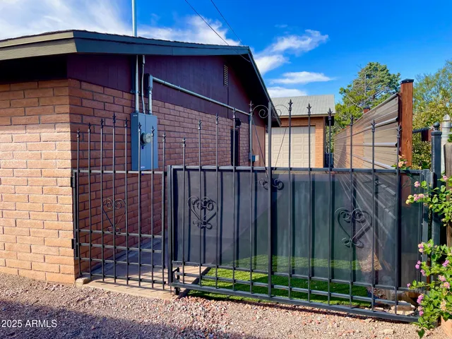 a view of a house with a small yard and wooden fence