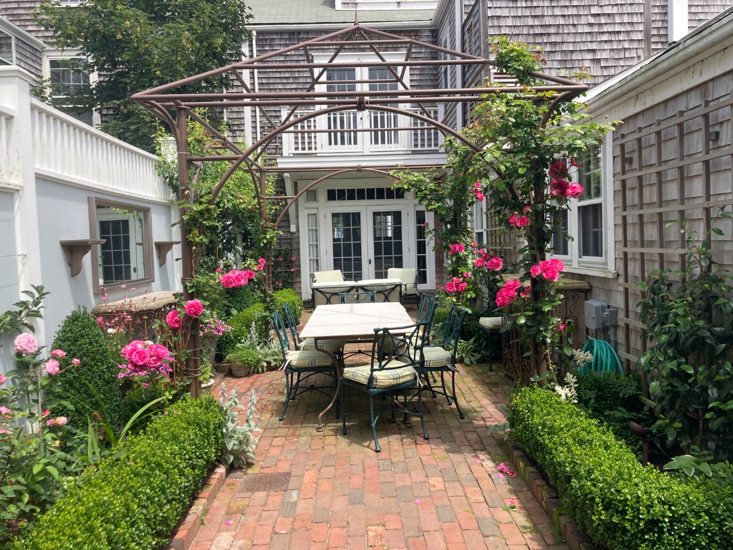 19 Orange Street Nantucket, MA 02554 - Photo 68 of 85 a view of a patio with a table and chairs and potted plants