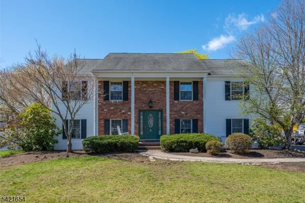 a front view of a house with yard and green space