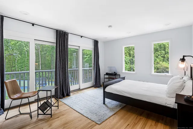 a spacious bedroom with a bed a table and chair