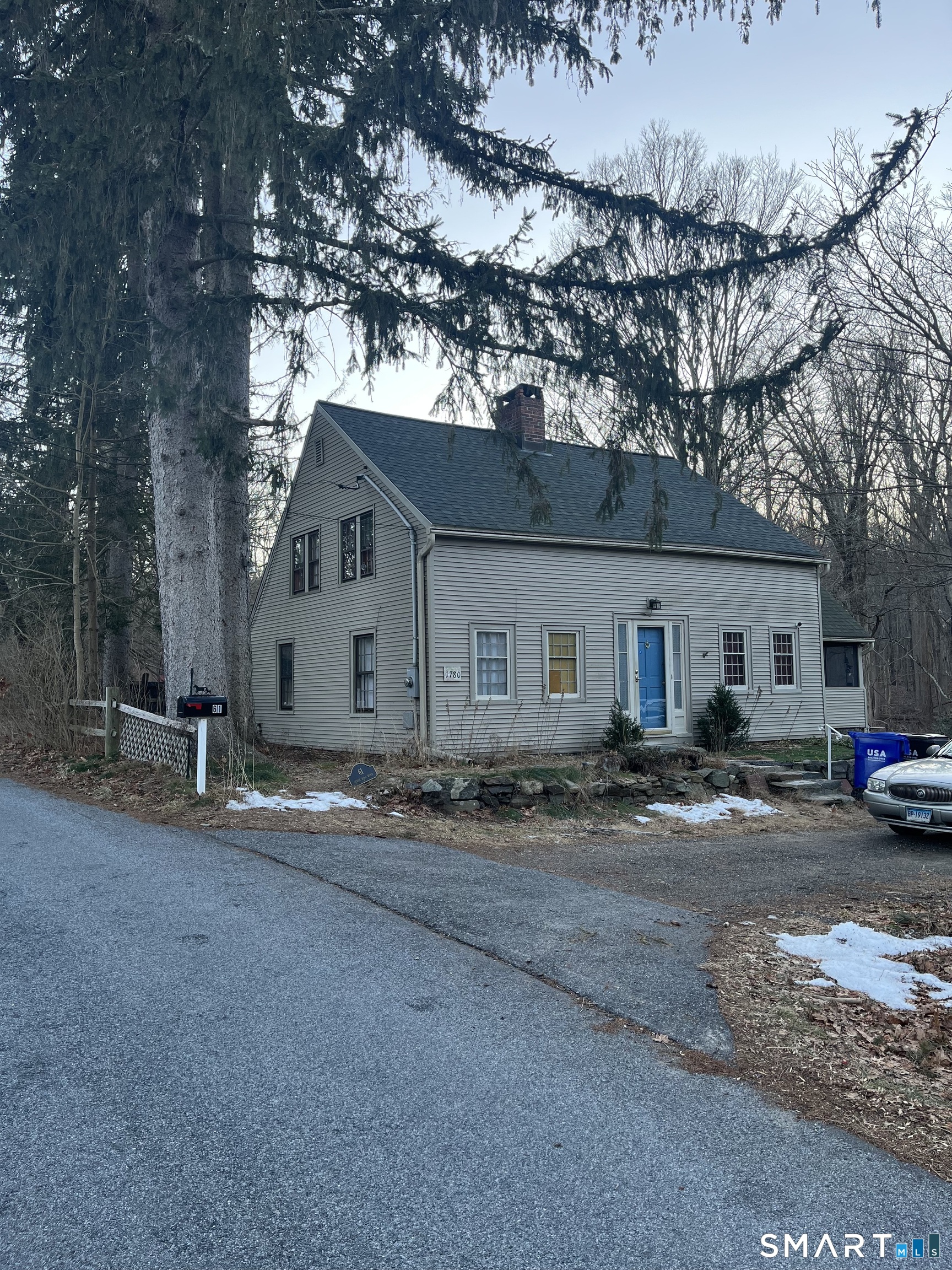 a view of a house with a yard and large tree
