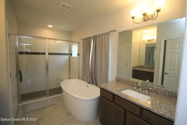 a bathroom with a granite countertop sink a toilet and shower