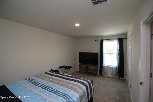 a bedroom with a bed and a television in it