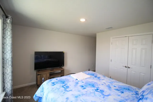 a bedroom with a bed and a flat screen tv
