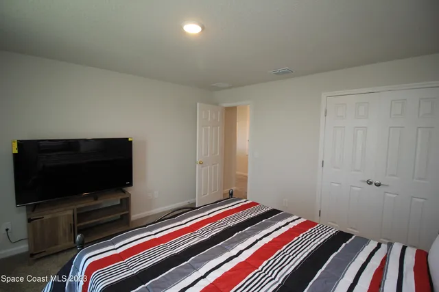 a room with a bed and a flat screen tv