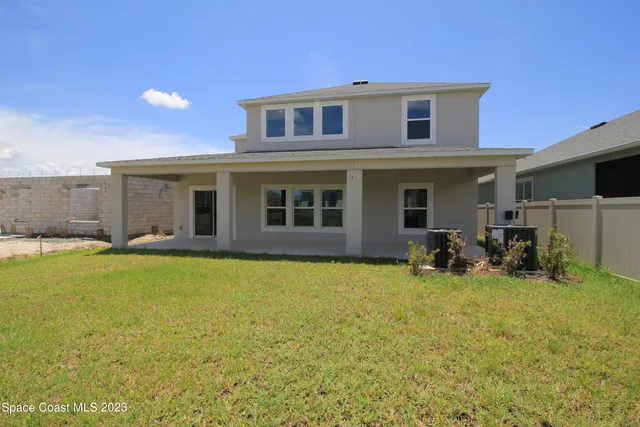 a view of a house with yard and sitting area