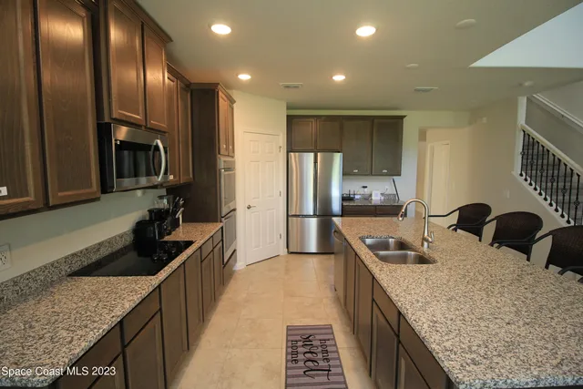 a kitchen with granite countertop counter top space a sink stainless steel appliances and cabinets