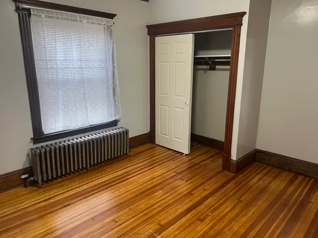 a view of a room with wooden floor and a door