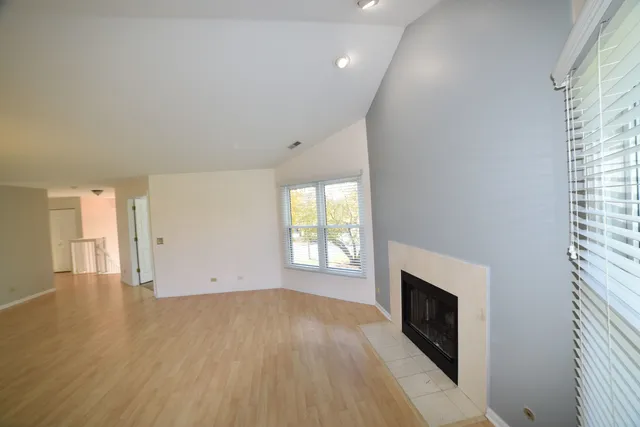 an empty room with wooden floor and fireplace