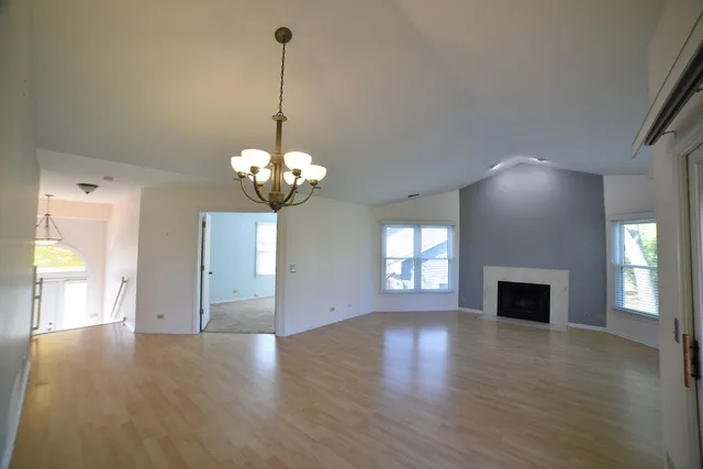 a view of a room with chandelier fireplace and wooden floor