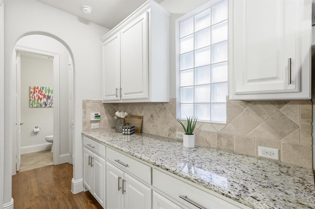 516 Sandy Lane Flower Mound, TX 75022 - Photo 15 of 38 Countertop space featuring white cabinetry with brushed nickel hardware, a light-toned granite countertop, and a tiled backsplash