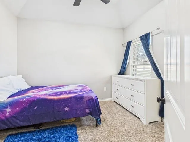 a bedroom with a bed and dresser with mirror