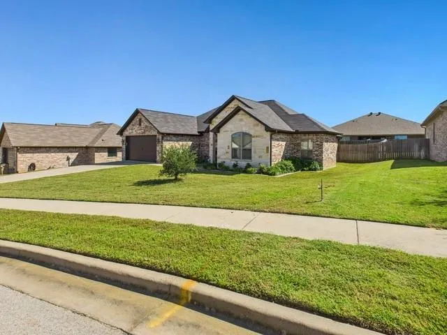 a view of a house with a big yard and large trees