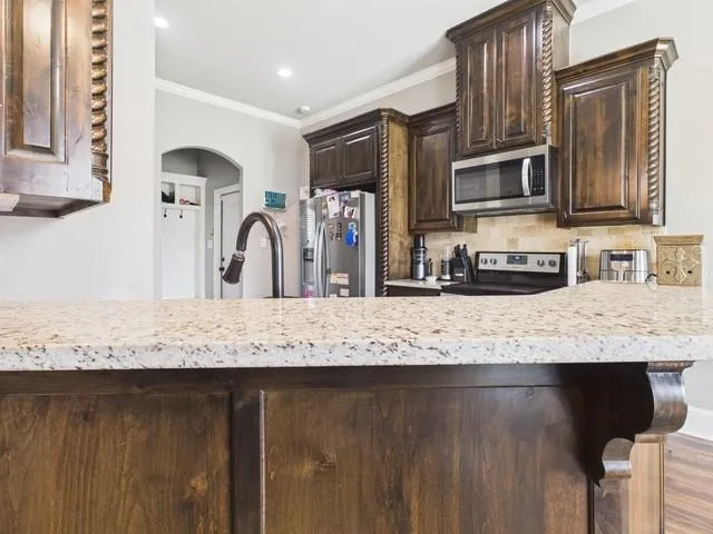 a kitchen with granite countertop a sink stainless steel appliances and cabinets