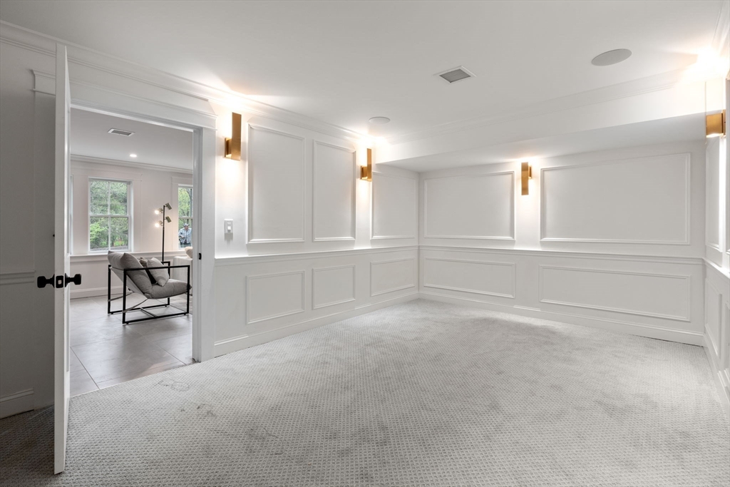 82 Deer Path Lane Weston, MA 02493 - Photo 27 of 42 an empty room with chandelier and windows