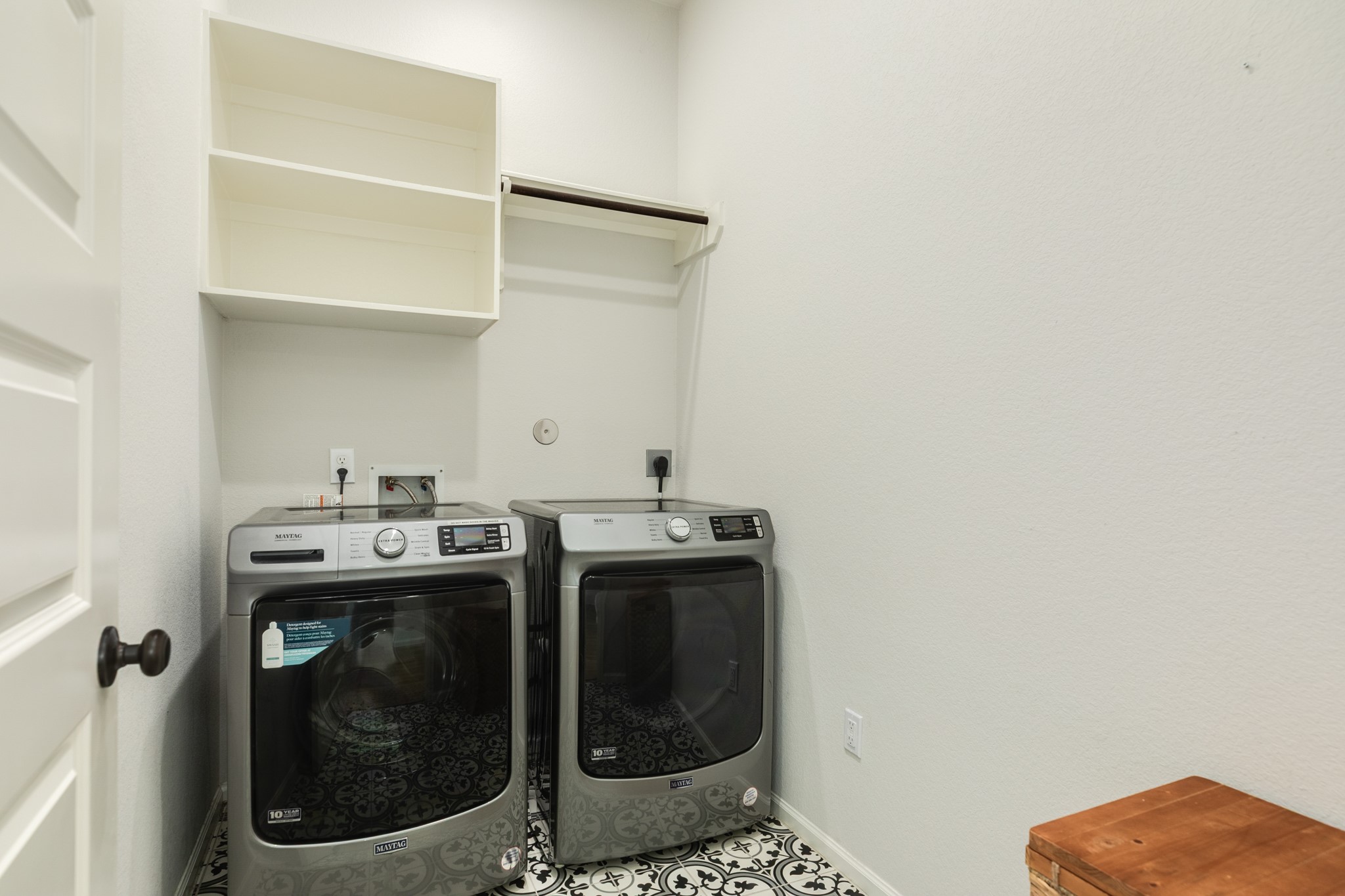 10115 Stride Court Rosharon, TX 77583 - Photo 24 of 40 Bright and functional laundry room featuring stylish modern tile flooring, convenient wall-mounted drying racks, and ample custom cabinetry for organized storage.