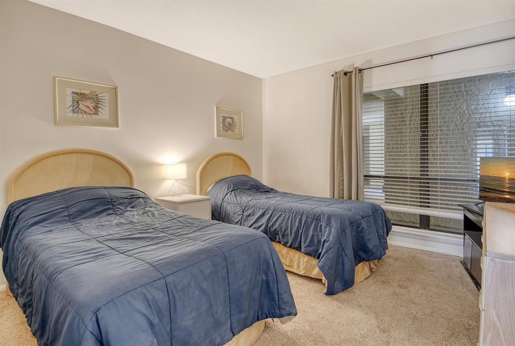 6157 Midnight Pass Road, Unit E63 Sarasota, FL 34242 - Photo 26 of 61 a bedroom with two beds and a window