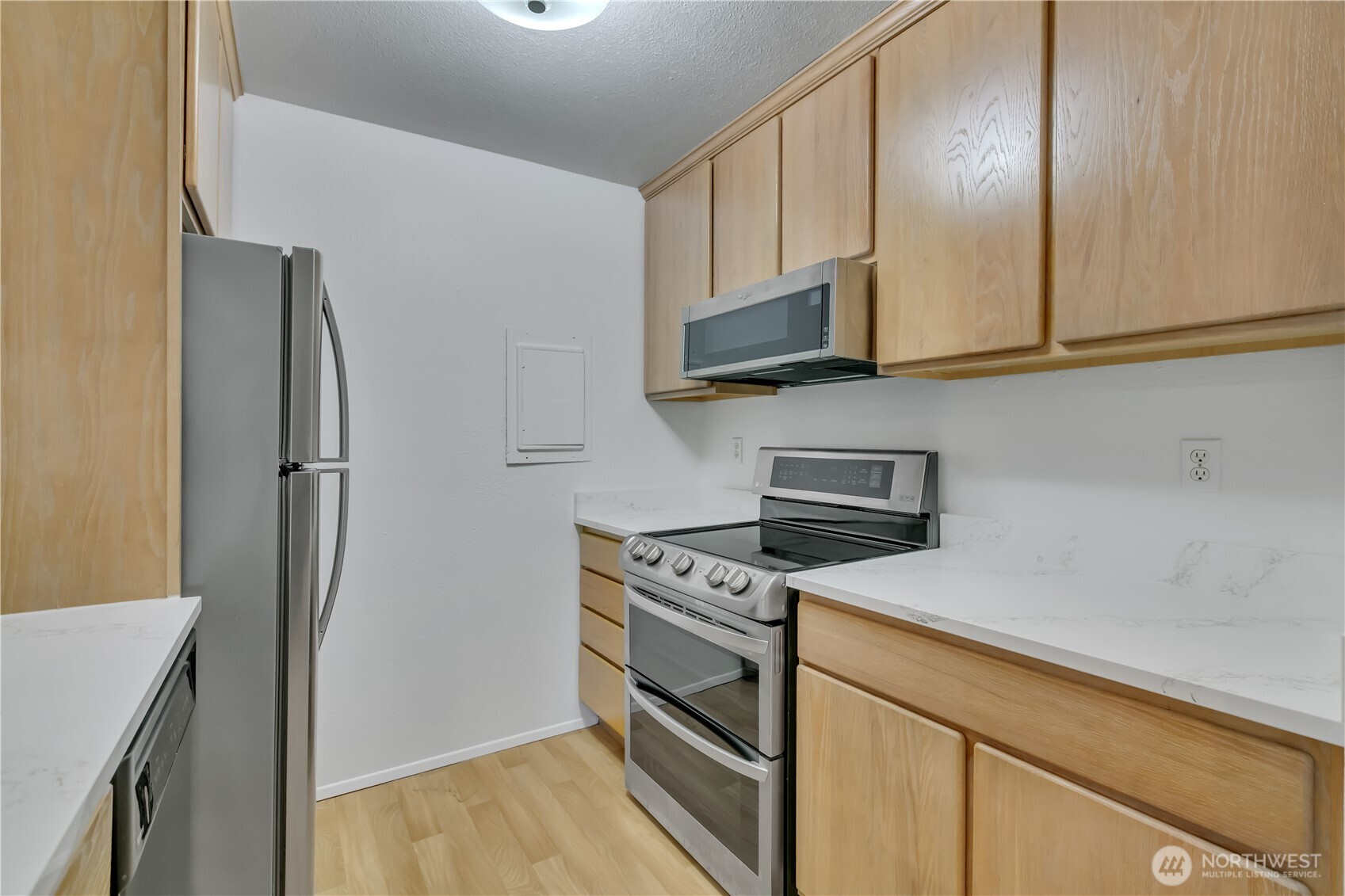 17527 149th Avenue Southeast, Unit B12 Renton, WA 98058 - Photo 13 of 27 a kitchen with stainless steel appliances white cabinets and a stove top oven