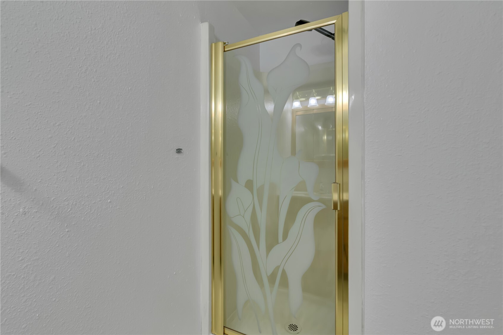 17527 149th Avenue Southeast, Unit B12 Renton, WA 98058 - Photo 19 of 27 a bathroom with a glass shower door and a mirror