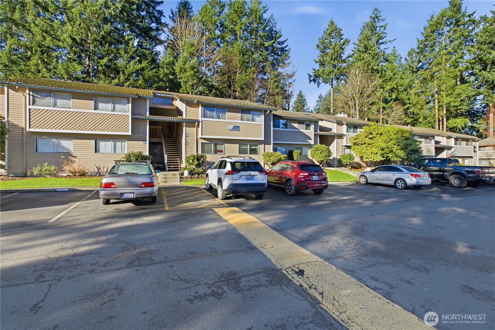 17527 149th Avenue Southeast, Unit B12 Renton, WA 98058 - Photo 2 of 27 a view of road with card parked on side and retail shops