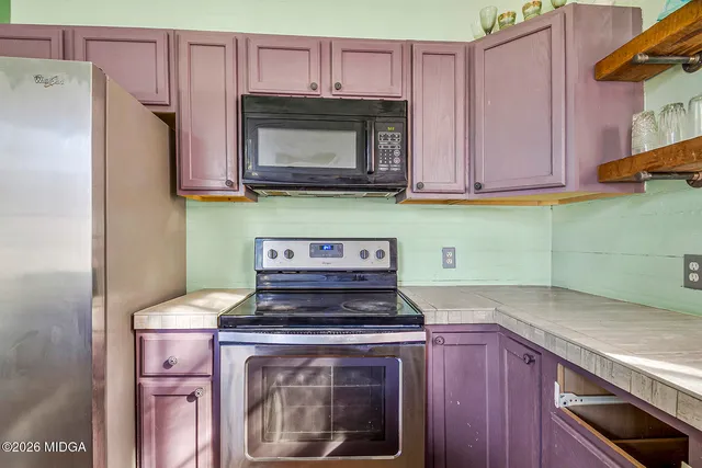 a kitchen with stainless steel appliances granite countertop a refrigerator and a stove