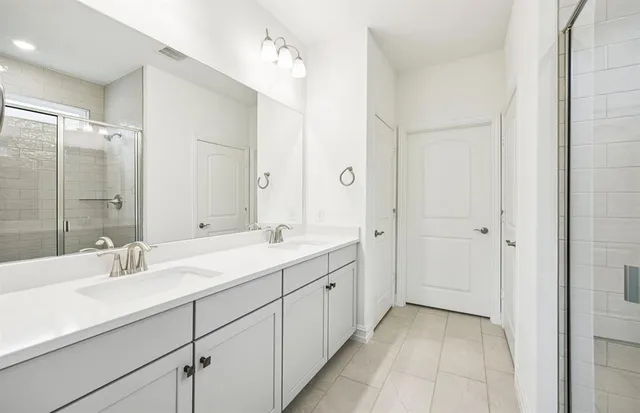 a bathroom with a double vanity sink mirror and