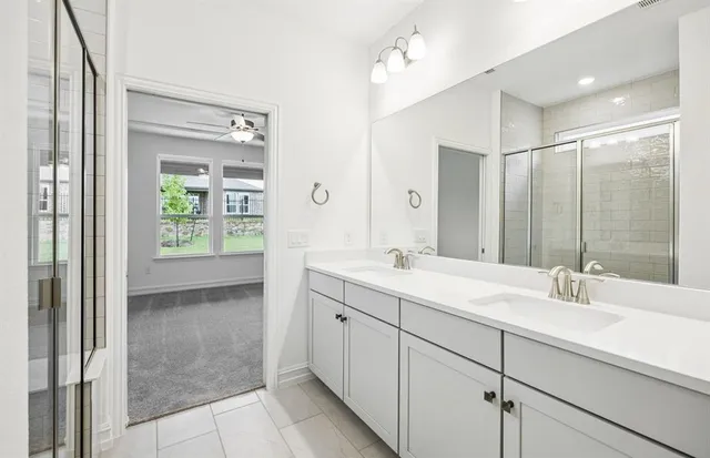 a bathroom with a double vanity sink mirror and shower