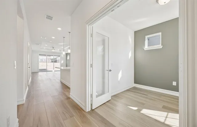 a view of a hallway with wooden floor