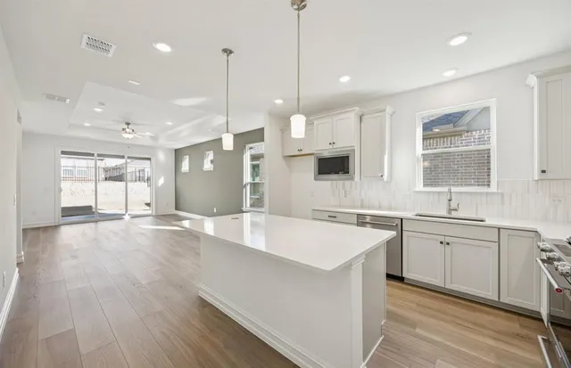 a large kitchen with kitchen island a sink stainless steel appliances and cabinets