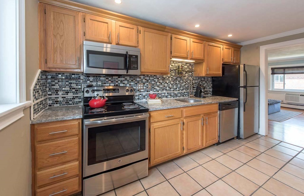 62 Bryon Road, Unit 6 Boston, MA 02467 - Photo 4 of 23 a kitchen with granite countertop cabinets stainless steel appliances and a counter space