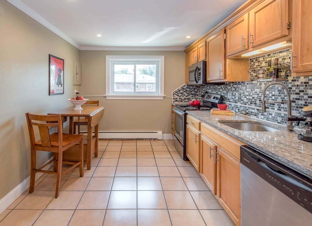 62 Bryon Road, Unit 6 Boston, MA 02467 - Photo 6 of 23 a kitchen with a sink a counter and chairs