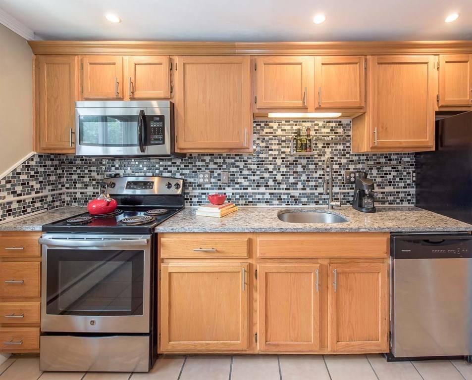 62 Bryon Road, Unit 6 Boston, MA 02467 - Photo 7 of 23 a kitchen with granite countertop a sink stove and cabinets