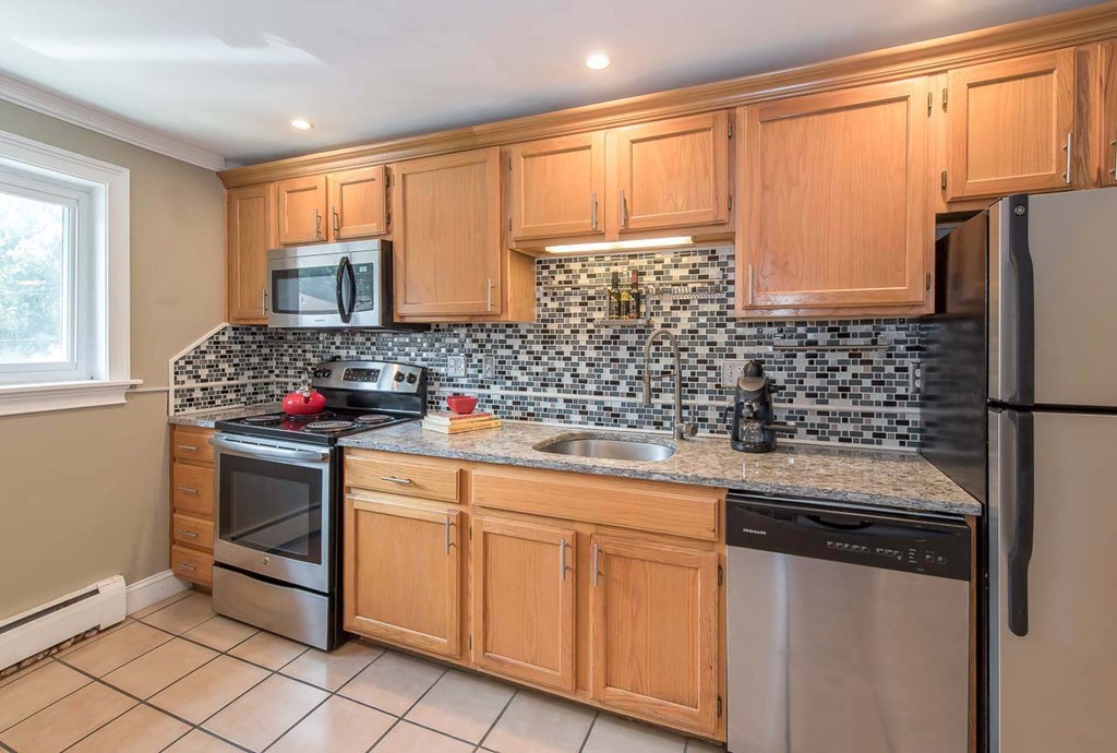 62 Bryon Road, Unit 6 Boston, MA 02467 - Photo 8 of 23 a kitchen with stainless steel appliances a stove sink and microwave