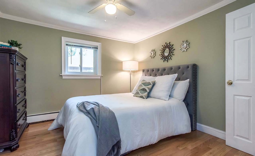 62 Bryon Road, Unit 6 Boston, MA 02467 - Photo 10 of 23 a bedroom with a bed and a chandelier