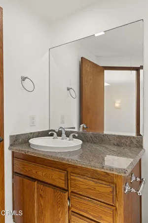 a bathroom with a granite countertop sink toilet and a mirror