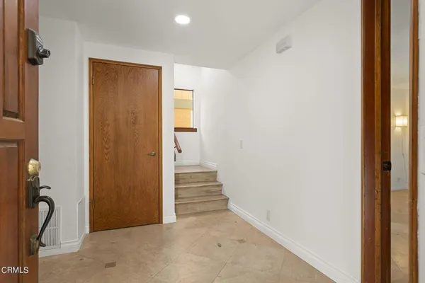 a view of a hallway with wooden floor and a bathroom