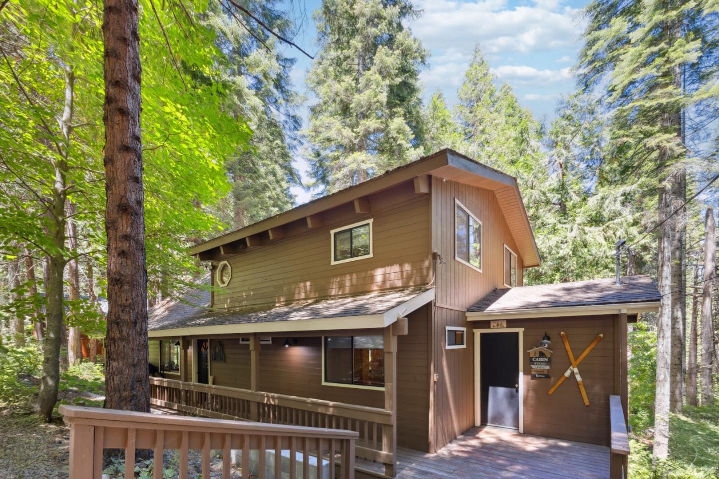 a front view of a house with a tree