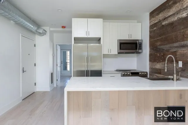 a kitchen with stainless steel appliances a refrigerator a sink a stove and cabinets
