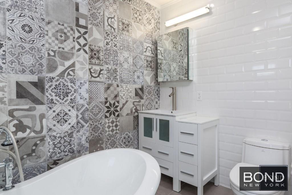 11-49 Welling Court, Unit 3 Queens, NY 11102 - Photo 7 of 8 a bathroom with a sink and a mirror